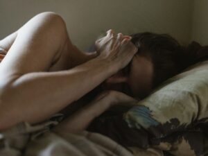 Depressed woman lying in bed