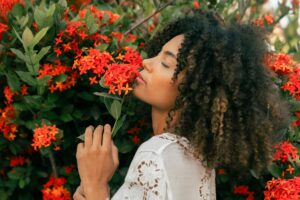 Woman standing in garden smelling flowers